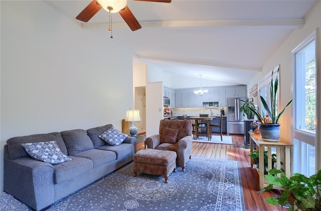 living area featuring light wood-style flooring, vaulted ceiling with beams, and ceiling fan with notable chandelier