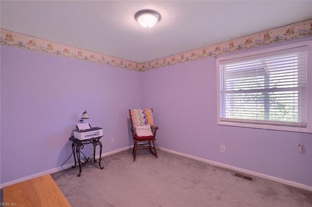 sitting room featuring baseboards, visible vents, and light carpet