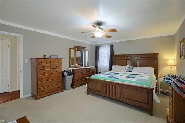 bedroom featuring a ceiling fan, crown molding, light colored carpet, and baseboards