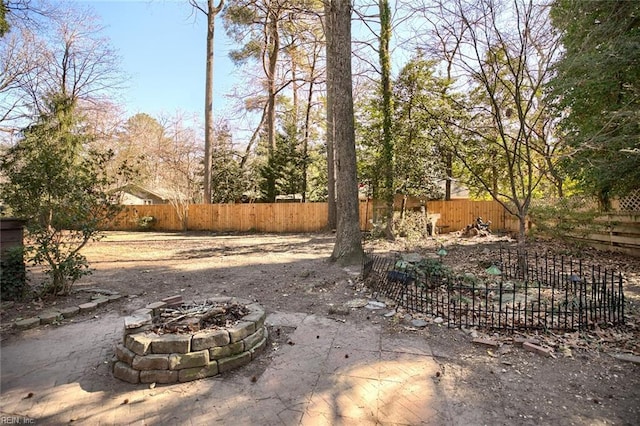 view of yard featuring an outdoor fire pit and a fenced backyard