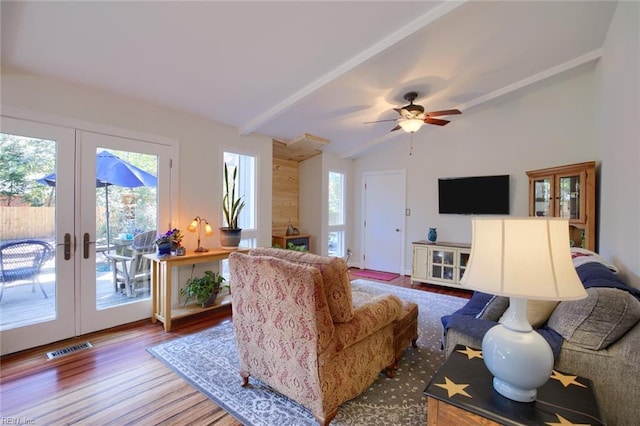 living area with visible vents, french doors, vaulted ceiling with beams, and wood finished floors