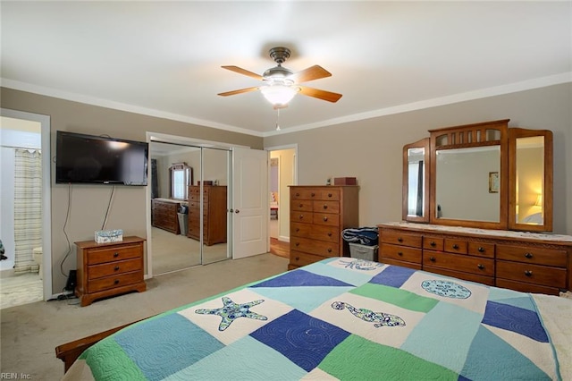 bedroom with connected bathroom, crown molding, carpet floors, a closet, and a ceiling fan