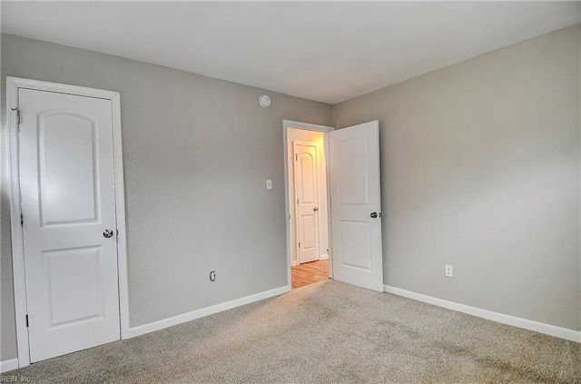 unfurnished bedroom featuring baseboards and carpet