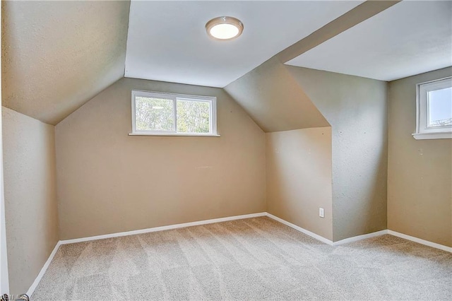 additional living space with vaulted ceiling, carpet, and baseboards