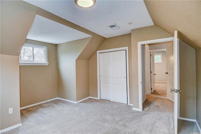 bonus room with visible vents, baseboards, and vaulted ceiling