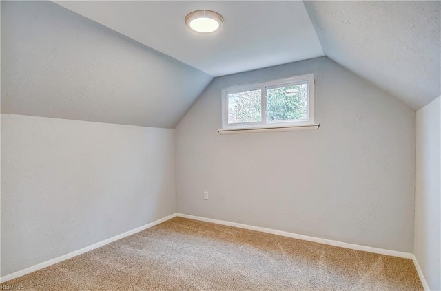 bonus room featuring baseboards, lofted ceiling, carpet floors, and a textured ceiling