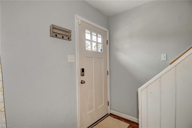 entryway with baseboards and wood finished floors