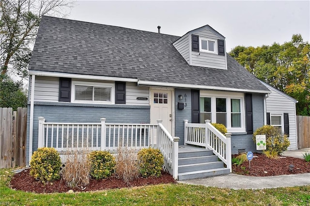 view of front facade with roof with shingles and fence