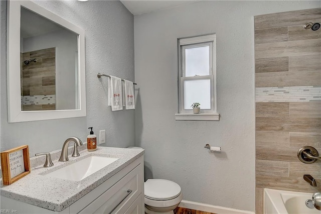 bathroom featuring vanity, baseboards, bathing tub / shower combination, toilet, and a textured wall