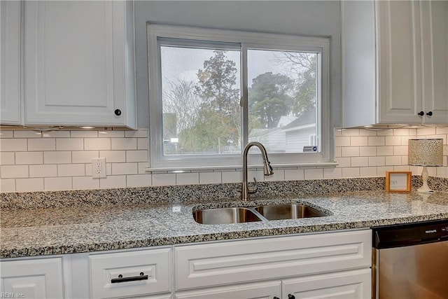 kitchen featuring stainless steel dishwasher, white cabinetry, and a sink