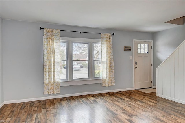 entryway with stairs, baseboards, and wood finished floors