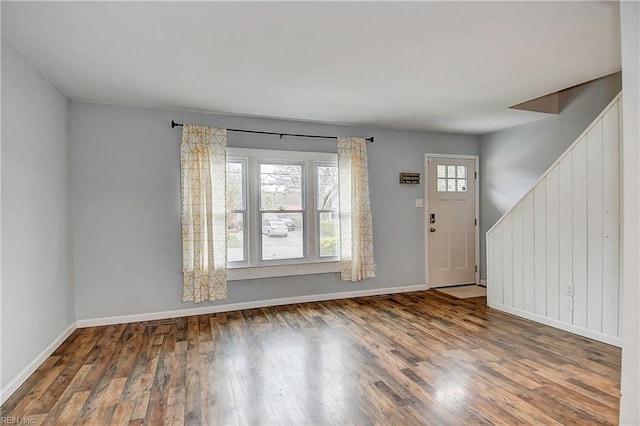 foyer entrance featuring stairway, baseboards, and wood finished floors