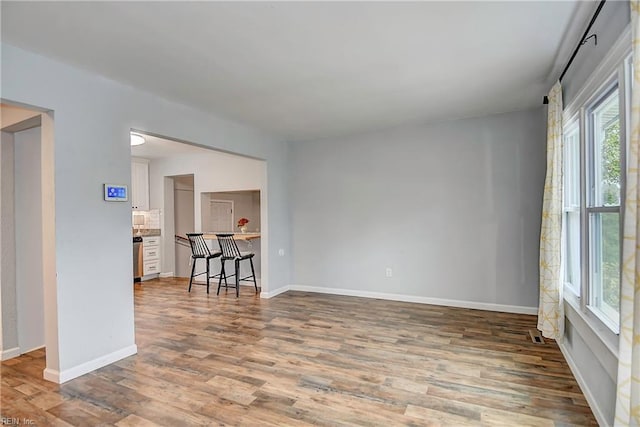 empty room with baseboards and wood finished floors