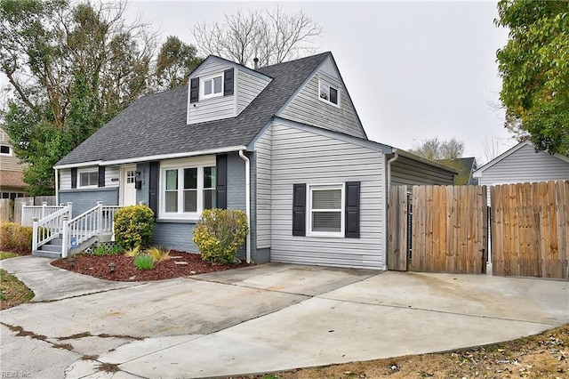 view of front of house with roof with shingles and fence