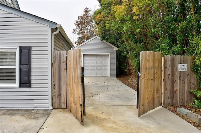 detached garage with driveway and fence