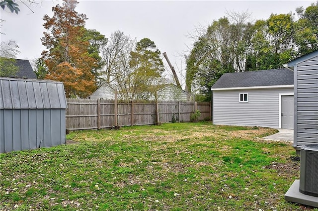 view of yard featuring an outbuilding, central AC unit, a fenced backyard, and a shed