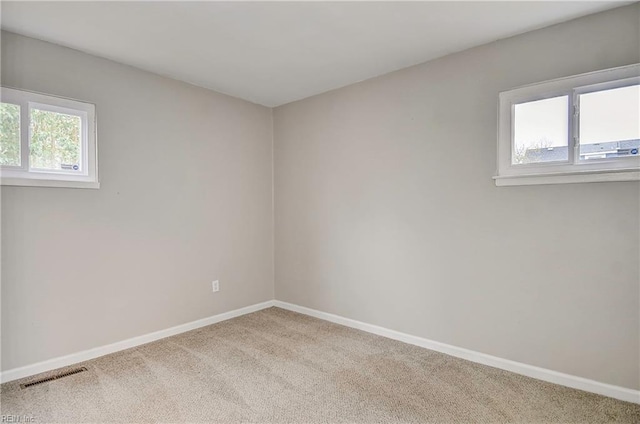 empty room with visible vents, baseboards, and carpet floors