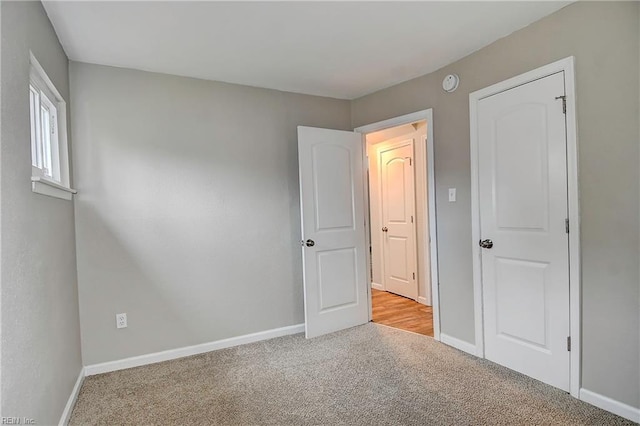 unfurnished bedroom with baseboards and carpet