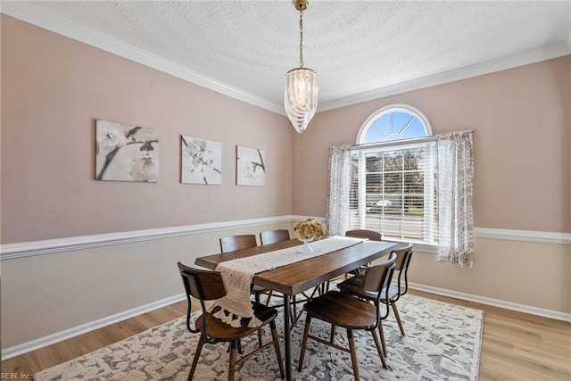 dining area featuring baseboards, wood finished floors, and a textured ceiling