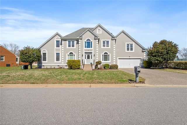 view of front of house with a front lawn, driveway, stucco siding, and an attached garage