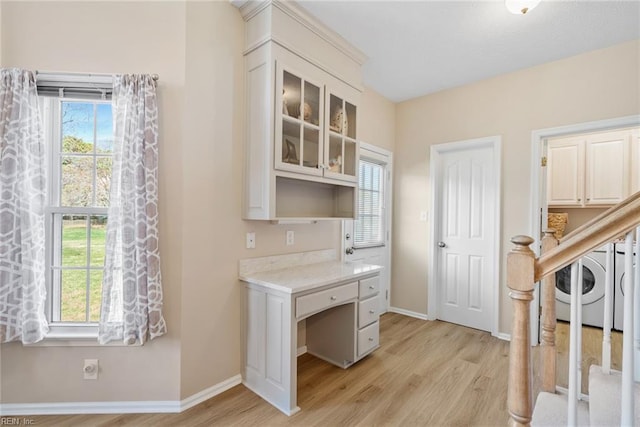 office area featuring washer / clothes dryer, a healthy amount of sunlight, and light wood finished floors