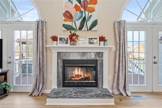 interior details with baseboards, a fireplace, visible vents, and wood finished floors