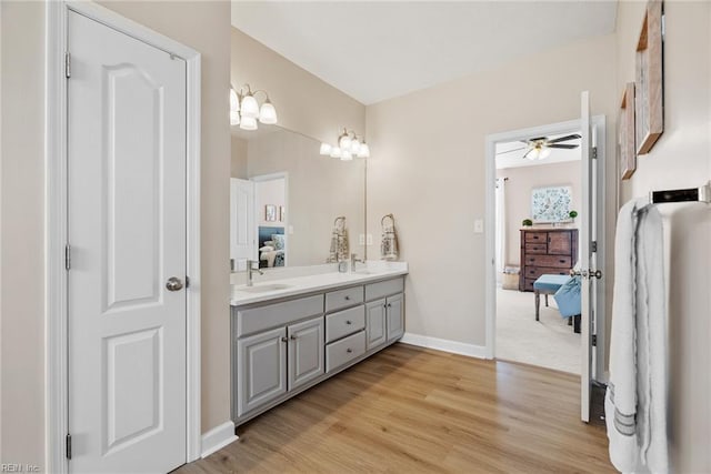 bathroom featuring ensuite bath, a sink, double vanity, and wood finished floors