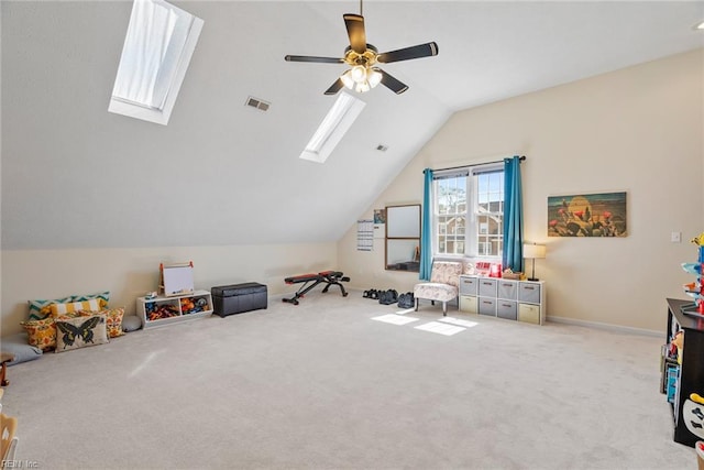 playroom featuring carpet flooring, visible vents, baseboards, a ceiling fan, and lofted ceiling with skylight