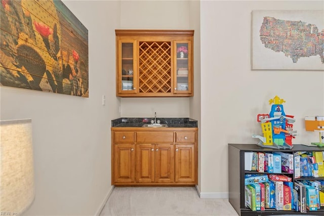 bar featuring baseboards, light colored carpet, indoor wet bar, and a sink