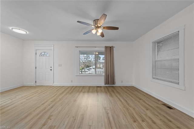 unfurnished room with light wood finished floors, visible vents, baseboards, and ceiling fan