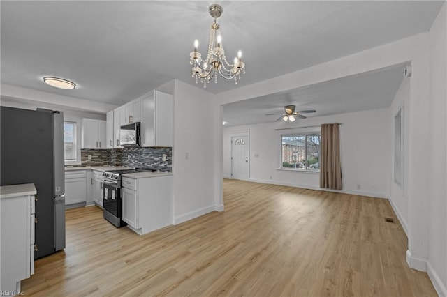 kitchen featuring stainless steel appliances, backsplash, white cabinets, and light countertops