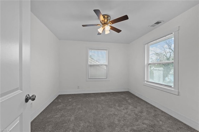 empty room featuring a ceiling fan, baseboards, visible vents, and dark carpet