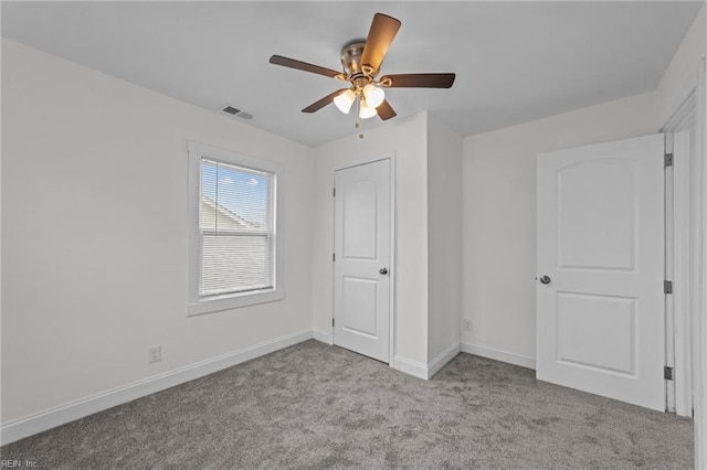 unfurnished bedroom featuring carpet flooring, visible vents, a ceiling fan, and baseboards