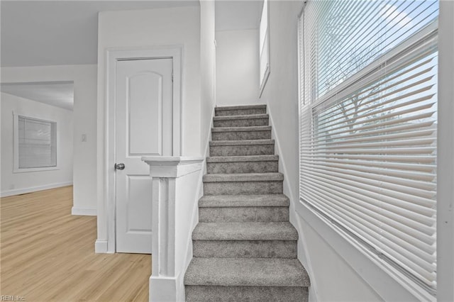 stairway with wood finished floors and baseboards