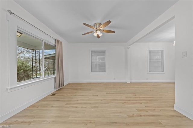 unfurnished room featuring a ceiling fan, light wood-type flooring, and baseboards