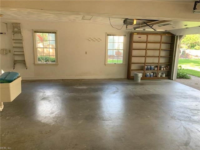 garage featuring a garage door opener and baseboards