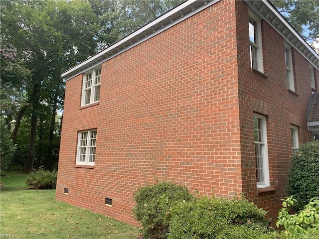 view of home's exterior with brick siding and crawl space