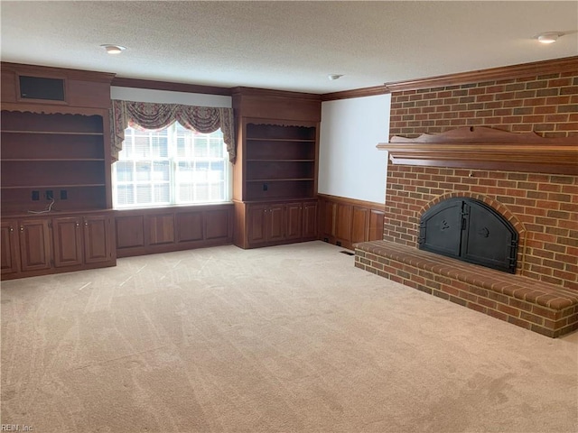 unfurnished living room with light carpet, a wainscoted wall, a textured ceiling, and ornamental molding