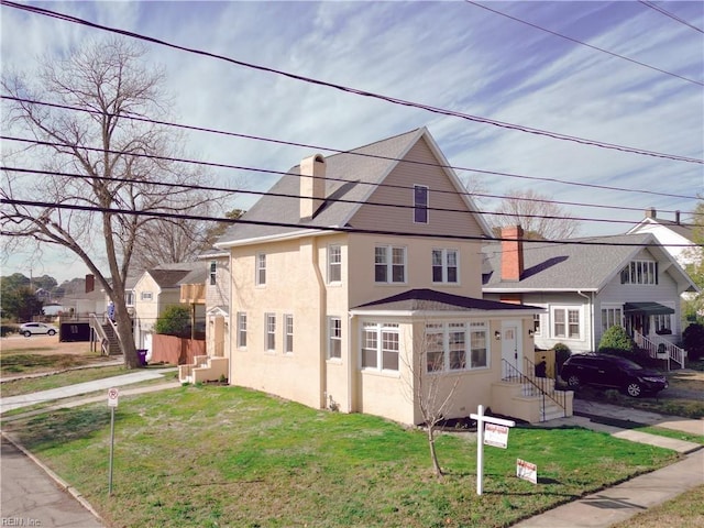 view of front of property featuring a residential view, stucco siding, a chimney, and a front yard