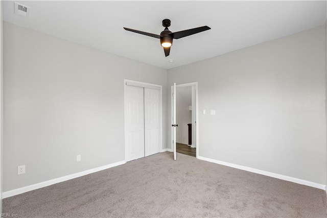 spare room with a ceiling fan, visible vents, carpet floors, and baseboards