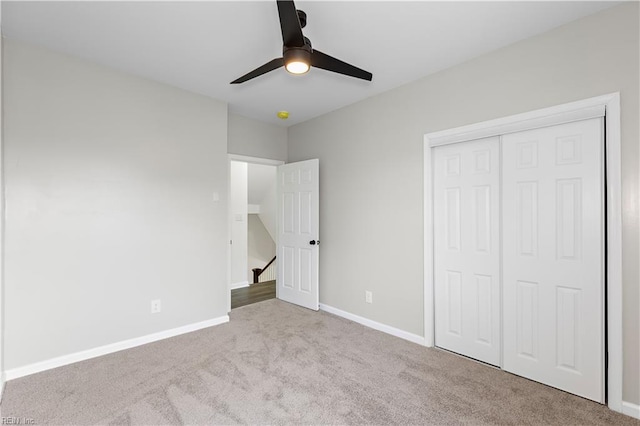 unfurnished bedroom with a closet, ceiling fan, baseboards, and carpet