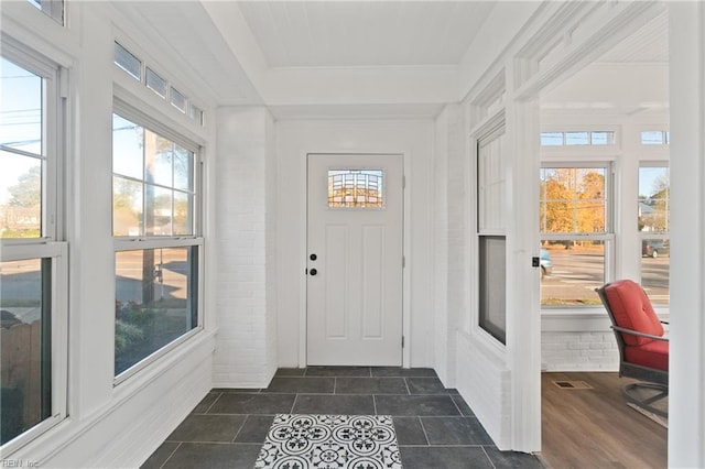 foyer entrance featuring brick wall