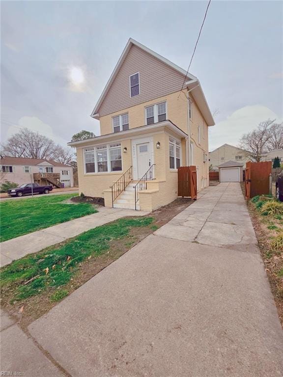 view of front of house featuring an outbuilding, a front lawn, a garage, and fence