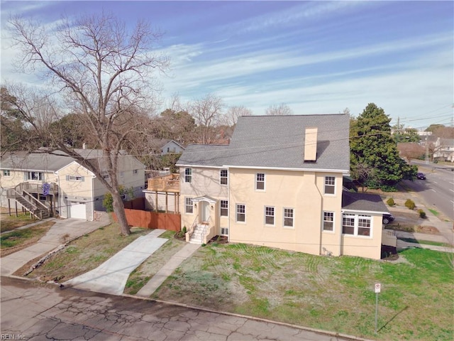 view of front of home featuring concrete driveway, a garage, a chimney, and stucco siding