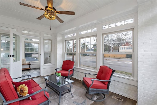 sunroom featuring a wealth of natural light, visible vents, and ceiling fan