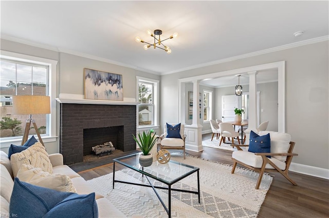 living area with a chandelier, wood finished floors, baseboards, and decorative columns