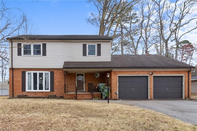 view of front of home with driveway, covered porch, an attached garage, a front yard, and brick siding