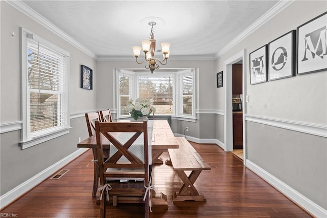 dining area with dark wood finished floors, an inviting chandelier, crown molding, and baseboards