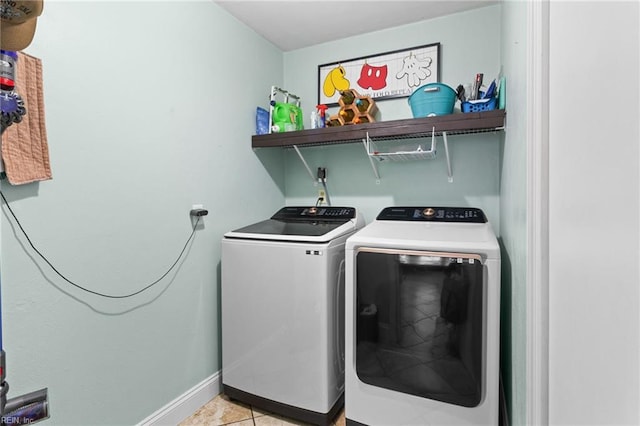 laundry area featuring laundry area, light tile patterned flooring, baseboards, and independent washer and dryer