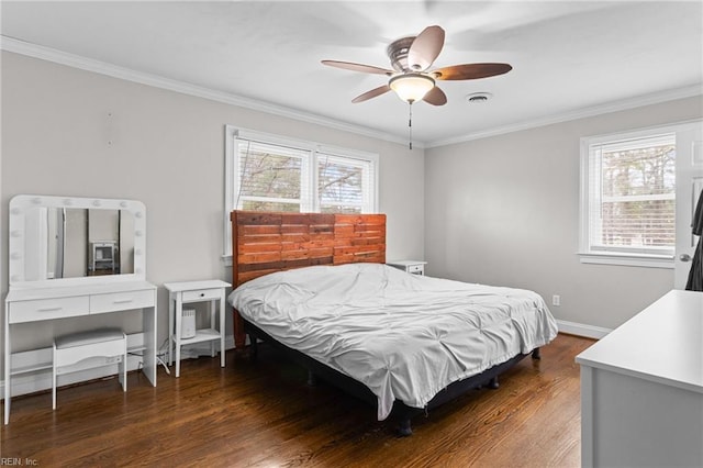 bedroom with dark wood finished floors, visible vents, baseboards, and ornamental molding